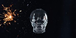 human skull with sparks over black background