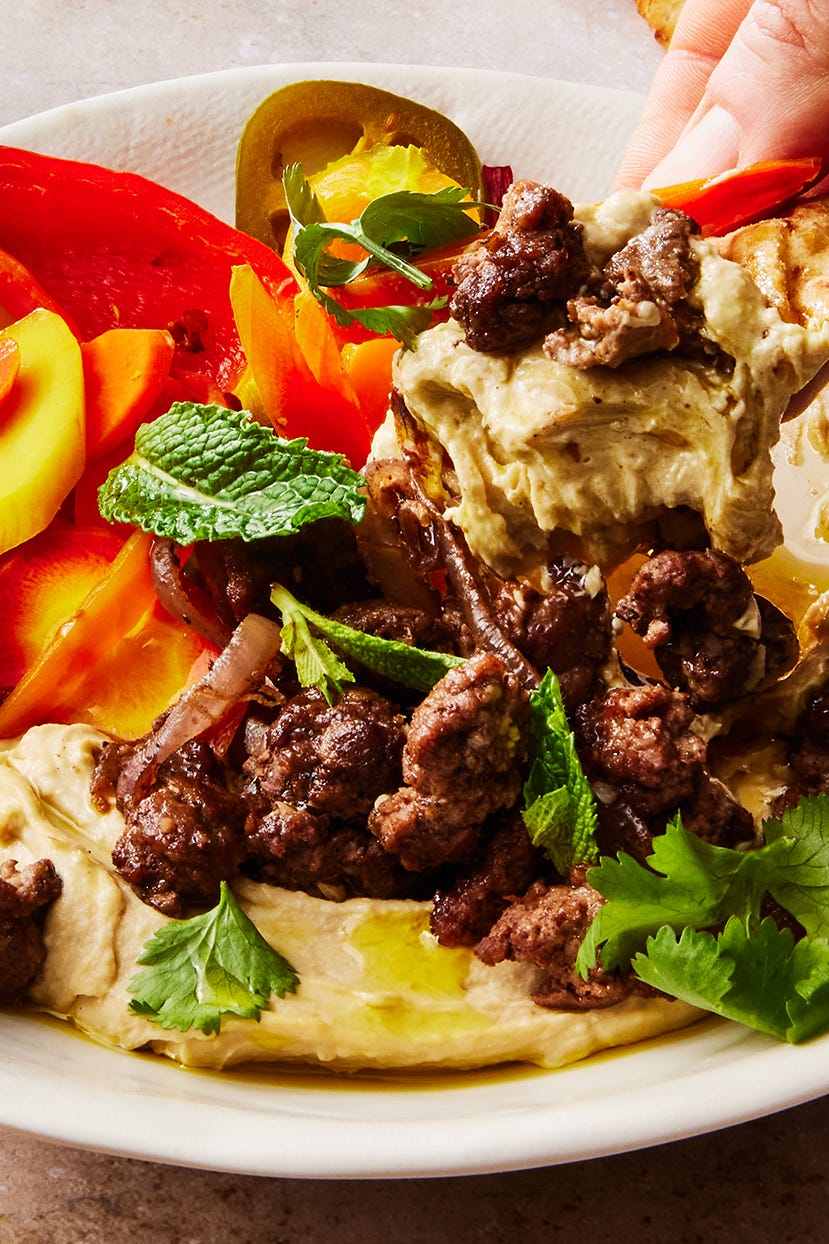 Hummus Bowl With Spiced Lamb hummus bowl topped with spiced lamb, homemade pickled vegetables, and herbs
