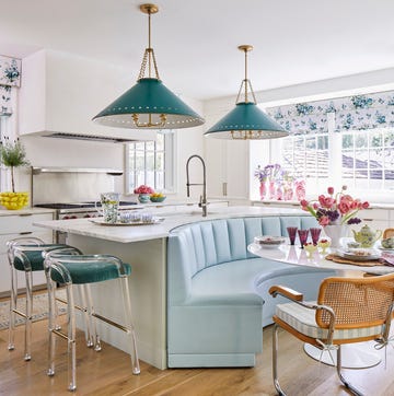 a channel tufted breakfast banquette backs up to a cleverly curved kitchen island