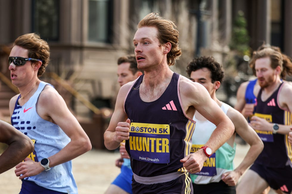 a group of people running wearing race bibs