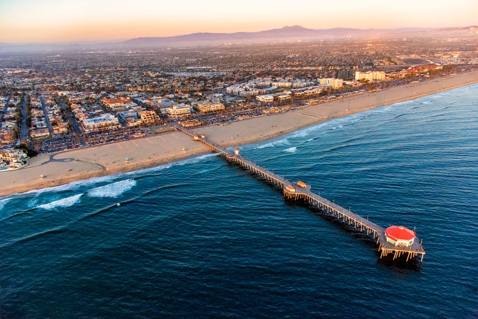 an aerial photo of a town on a beach with a large pier