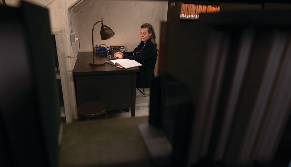 victoria patterson writing at her desk in the basement photographed on january 25, 2024