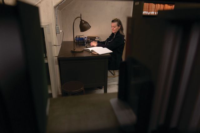 victoria patterson writing at her desk in the basement photographed on january 25, 2024