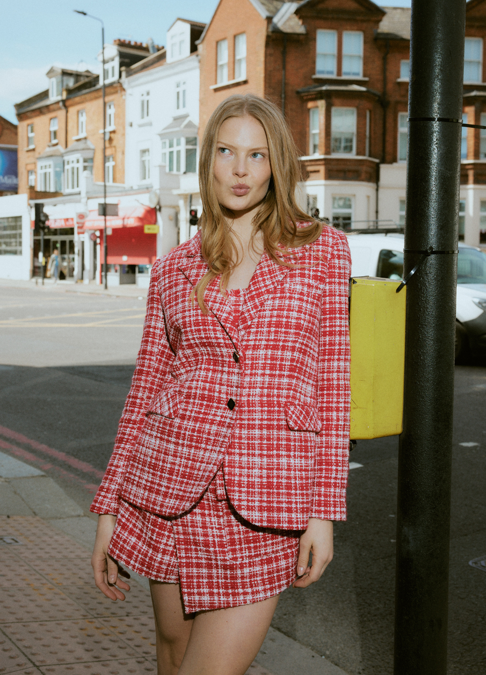 hurr rental flex launch featuring a woman wearing a red and white checkered suit jacket and skirt