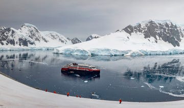 expedition ship navigating icy waters surrounded by snowcovered mountains