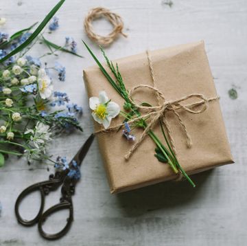 a brown paper wedding gift with wild flowers and scissors nearby