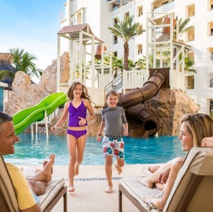 a family enjoys the pool and waterslide at the hyatt ziva los cabos, a good housekeeping pick for best all inclusive family resorts
