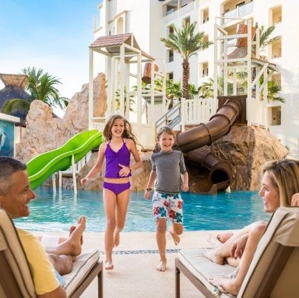 a family enjoys the pool and waterslide at the hyatt ziva los cabos, a good housekeeping pick for best all inclusive family resorts