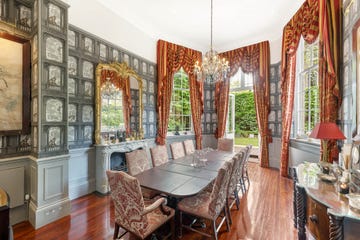 a dining room with a chandelier, opulent window treatments, and other luxe details