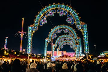 a vibrant festival scene with illuminated arches and crowds at hyde park winter wonderland