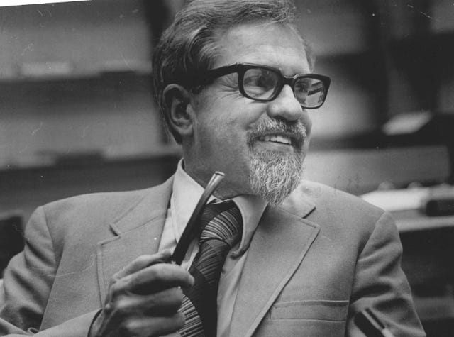 j allen hynek smiling and holding pipe