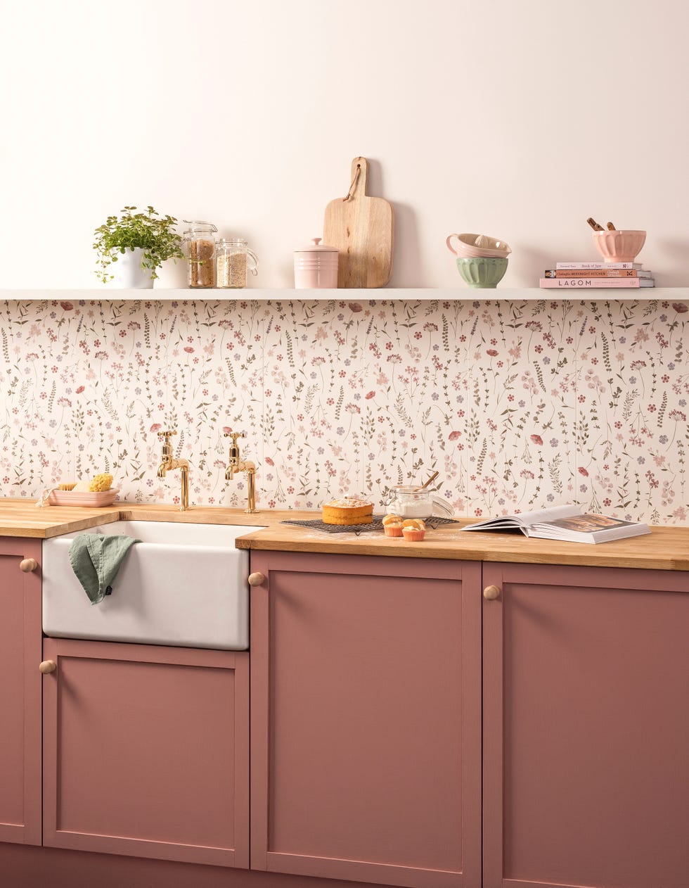 a pink kitchen with pastel floral print wall tiles and open shelving