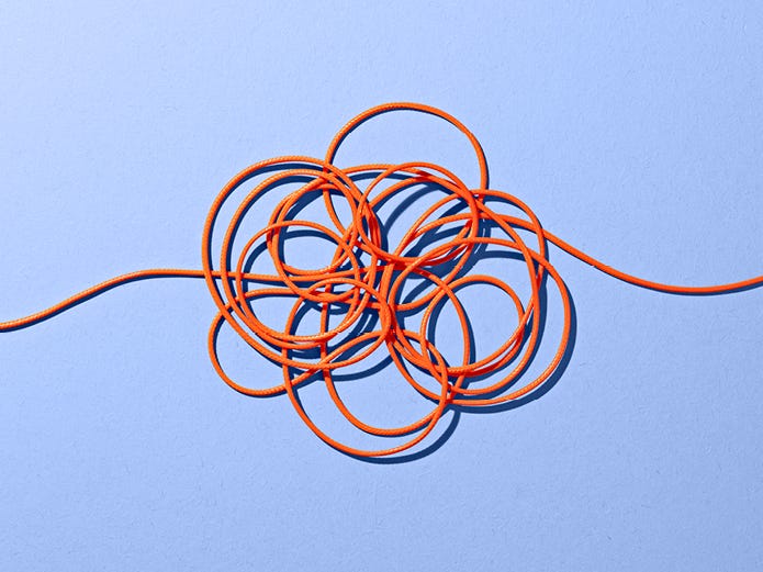 tangled orange thread in front of blue background