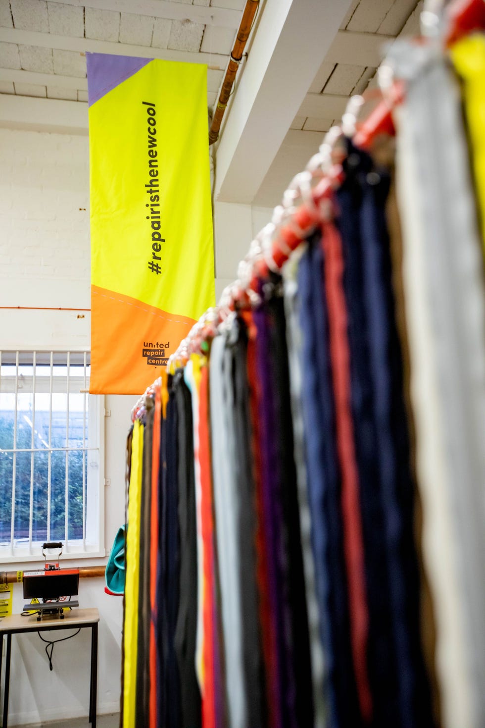 a group of colorful ties from a ceiling