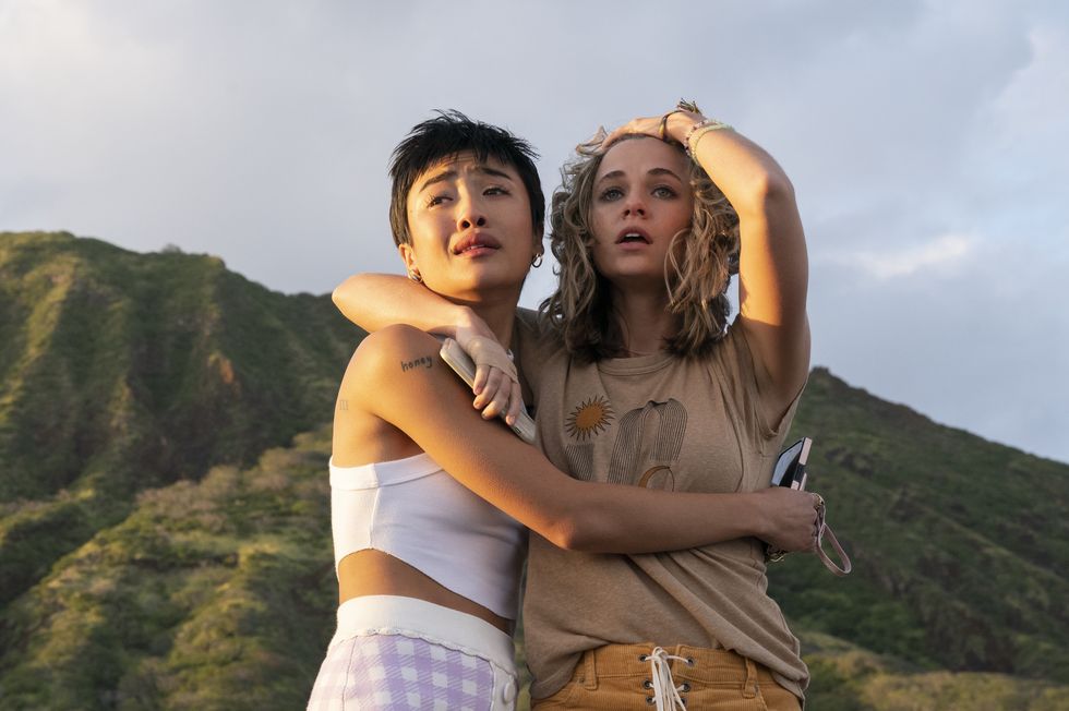 two young ladies hugging each other standing in front of a mountain looking worried in i know what you did last summer