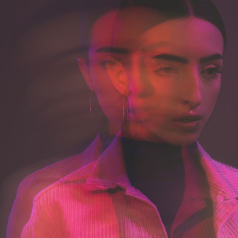 abstract portrait of a young woman bathed in pink light