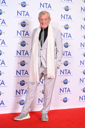 ian mckellen in the winners room the national television awards 2023 he is wearing a white suit with a black shirt and black and white tie