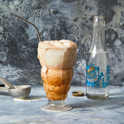 an overflowing ice cream float with a metal straw
