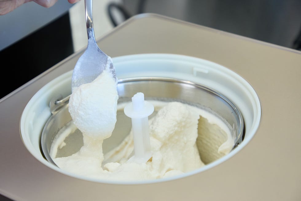 ice cream maker with a spoon scooping out vanilla ice cream
