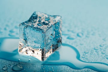 ice cube with water drops on a blue background the ice is melting,romania