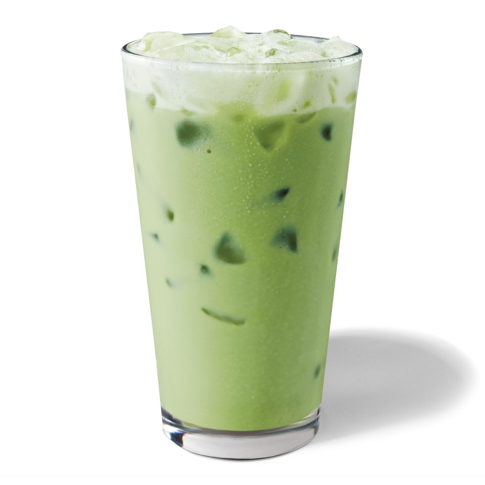 shot of iced matcha green tea latte, green in colour in glass with ice