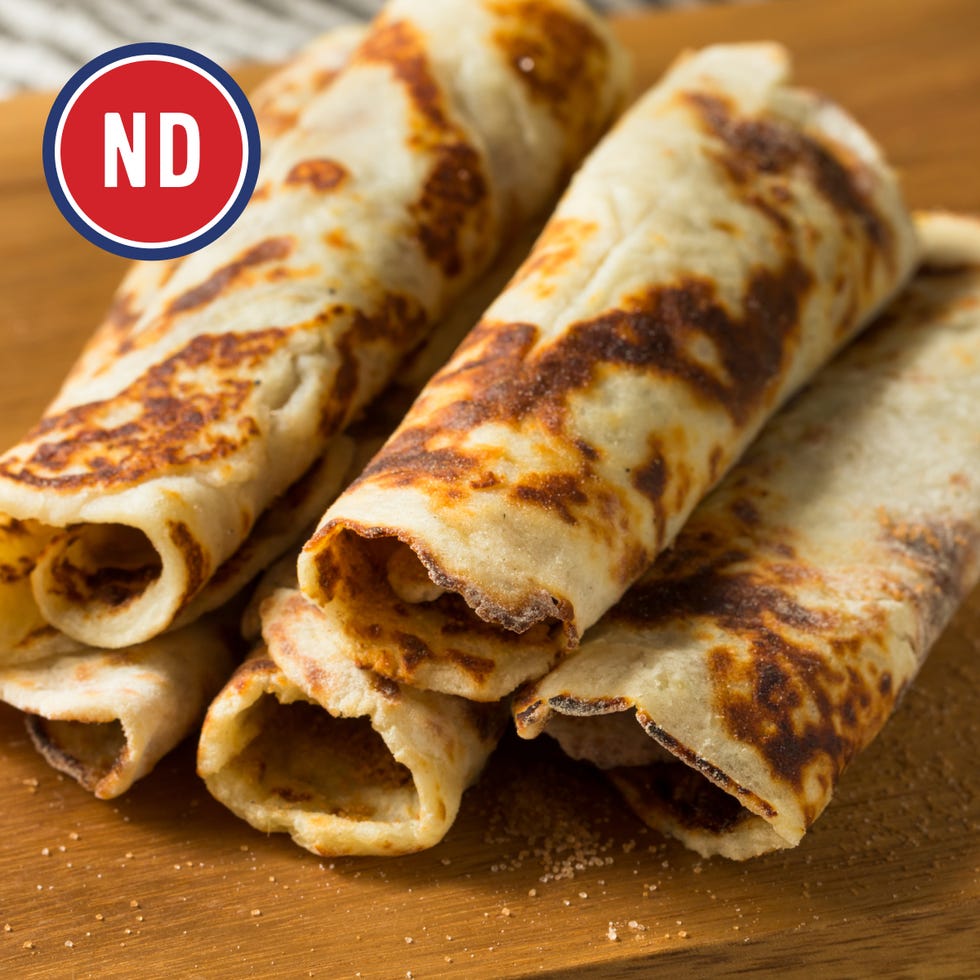 three rolled tortillas on a wooden surface