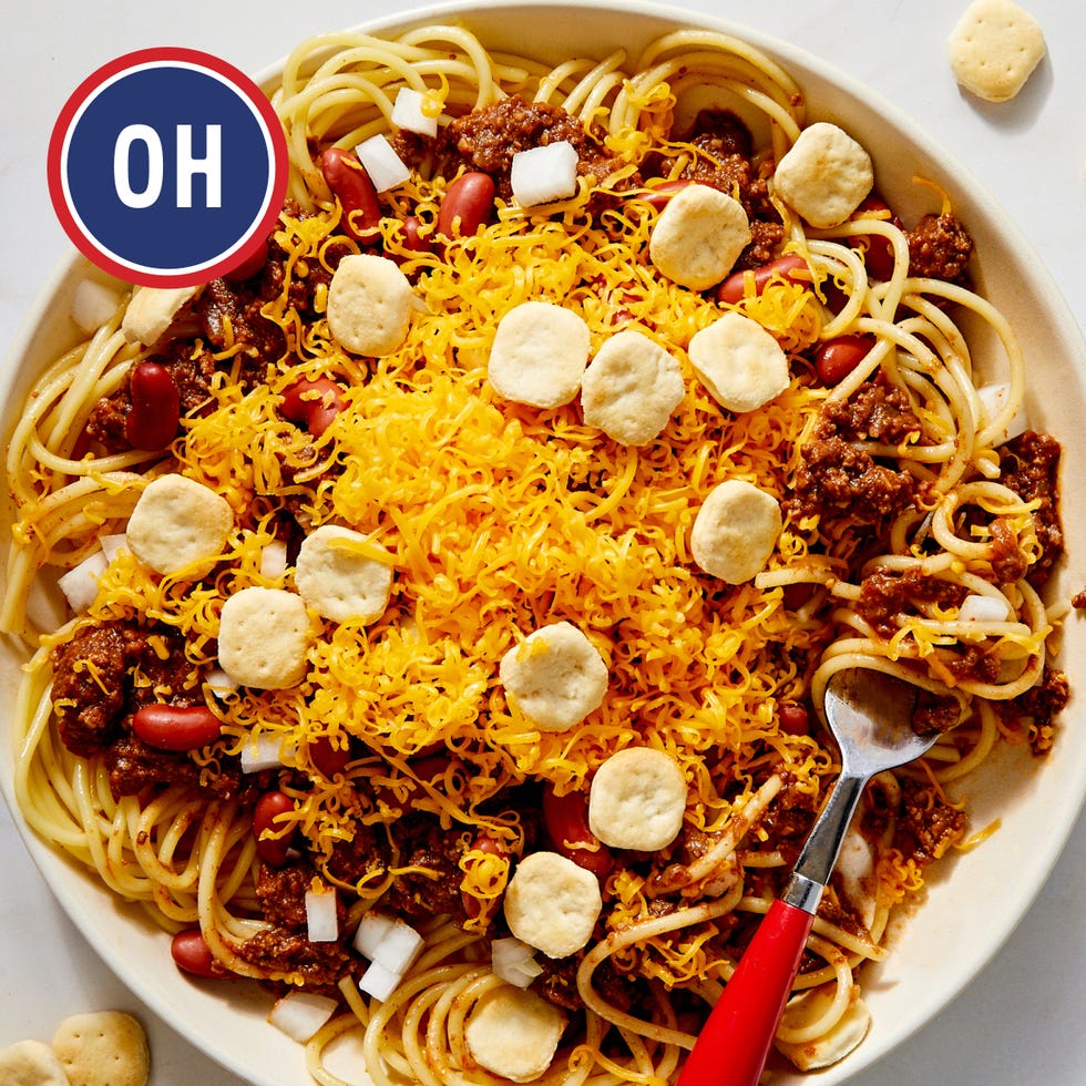 bowl of spaghetti topped with chili cheese and crackers