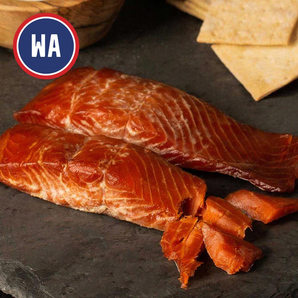 smoked salmon fillets arranged on a dark surface with a few pieces cut off