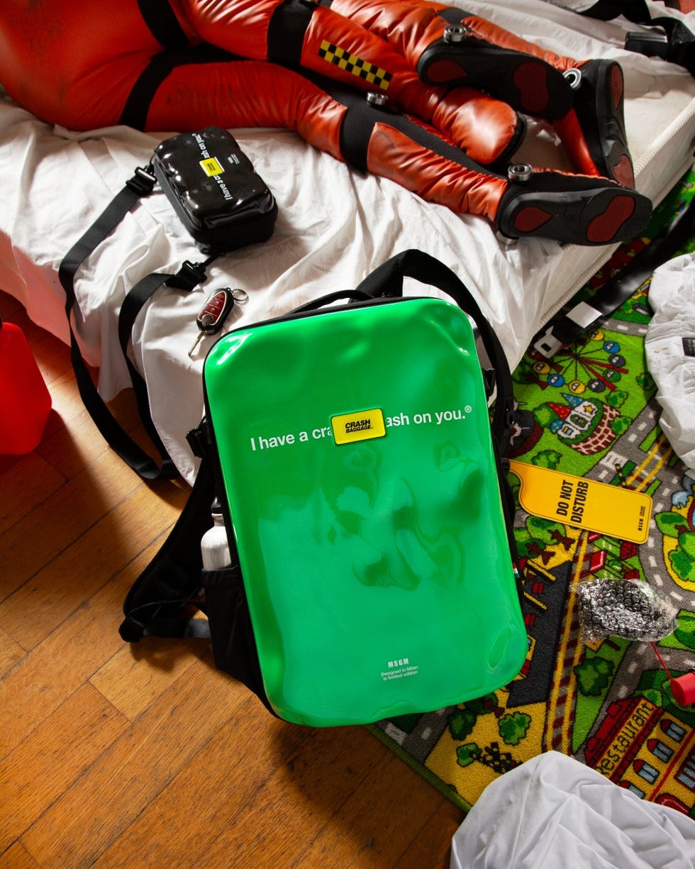 a green bag with a gun on it next to a backpack