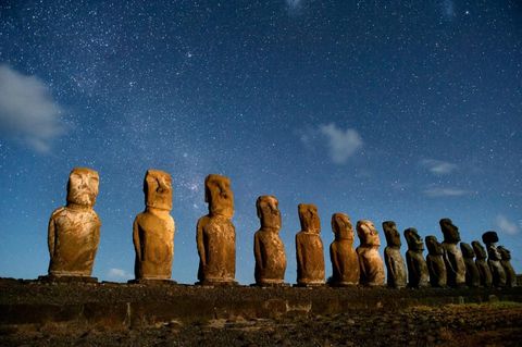 In hun spookachtige rijen wekken de Paaseilandbeelden moai genaamd ons onderbewustzijn op De stenen beeldenrij tegelijkertijd onwerkelijk en diep gekend door ons roept de voorouderverering op precies zoals de eilandbewoners waarschijnlijk bedoeld hadden Ons voorstellingsvermogen hapert bij de eenzaamheid De Polynesirs maakten hun epische reis over de uitgestrekte Stille Oceaan naar dit spikkeltje van een eiland en vervolgens kwam er bijna duizend jaar niemand in de buurt Overgelaten aan hun eigen voorstellingsvermogen vonden de eilandbewoners hun eigen versie van oneindigheid uit In het donker onder een zuidelijke sterrenhemel hebben de reuzenbeelden de kracht om in je gedachten te komen spoken zoals weinig ander plekken op aarde dat kunnenIconisch beeld Tongariki met de lange rij moai erboven