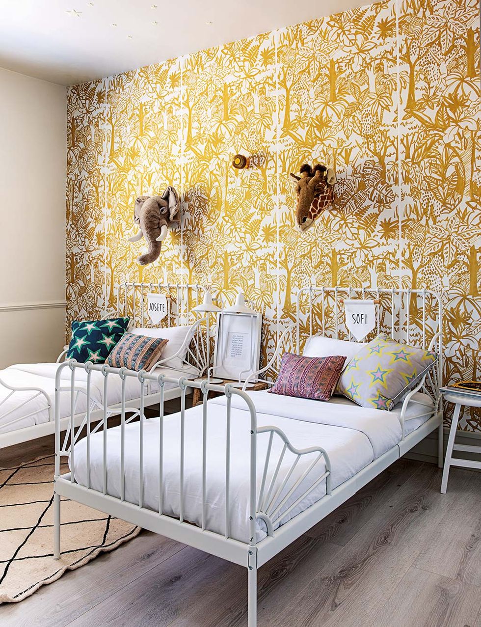 Una habitación infantil de estilo boho con papel pintado