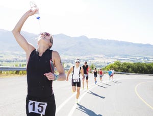 runner spraying water on rural road