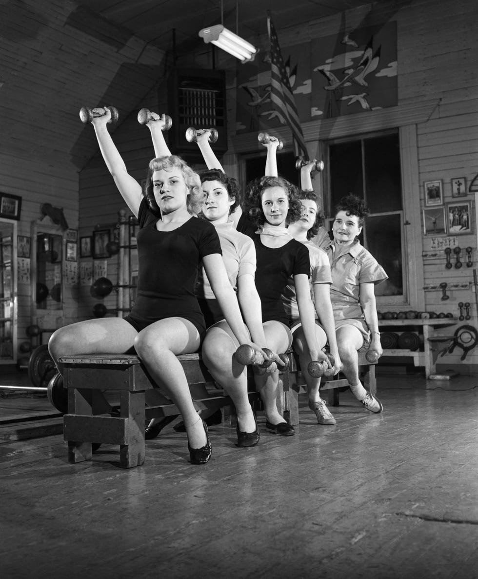 women on bench exercising with barbells