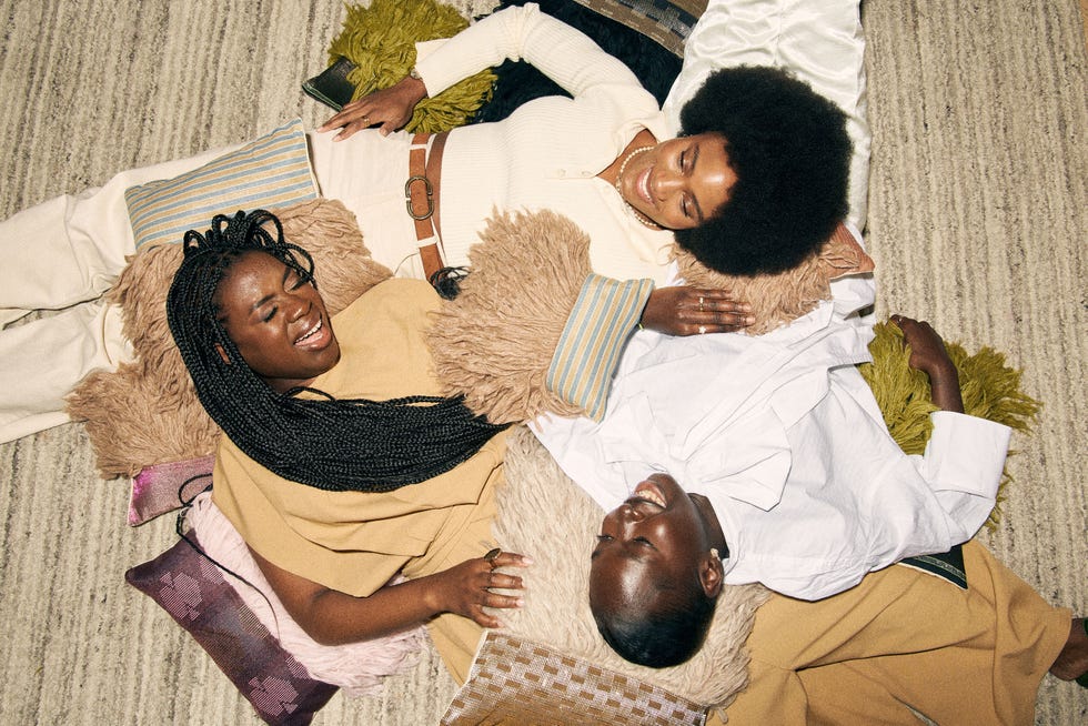 a group of individuals relaxing on a textured surface surrounded by various textiles