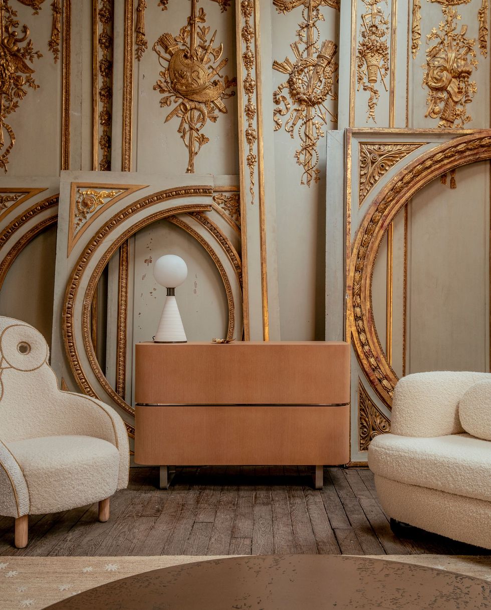 Two bouclé chairs in front of neoclassical panels