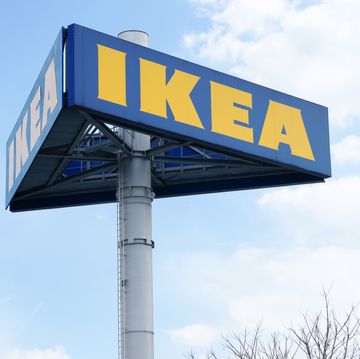 graz, austria   march 26, 2011 large ikea logo on pole in graz clouded sky in background tree is partly visible in lower part of image ikea is producer of low price furniture located south of stockholm in sweden with branches all over the world