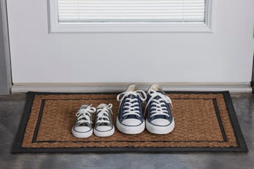 two pairs of sneakers on a doormat