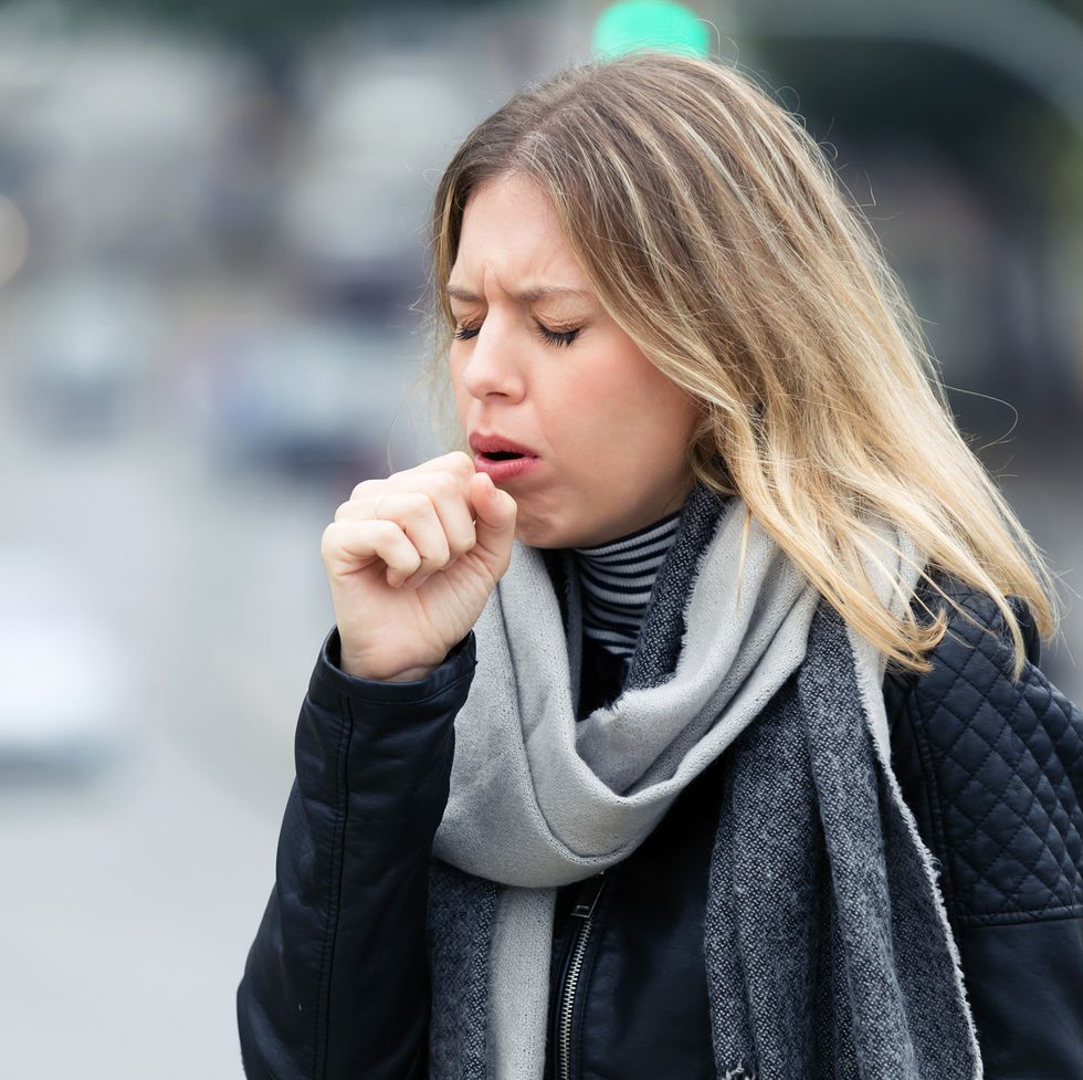 illness young woman coughing in the street