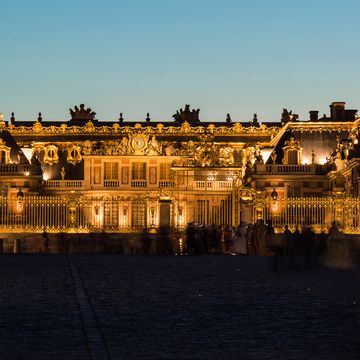 Illuminated Palace Of Versailles Against Sky At Dusk