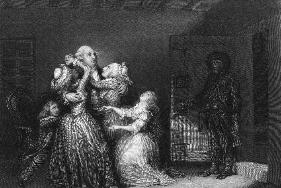 an illustration of the last goodbye between louis xvi and his family before he is led off to execution by the guillotine, illustration shows louis xvi being hugged by his wife, marie antoinette, and daughters and his son, the dauphin louis xvii, as a jailor stands by the door on the right with his keys