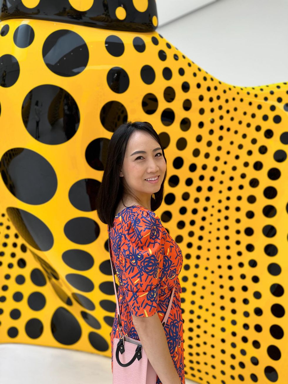 a person standing in front of a large yellow and black wall
