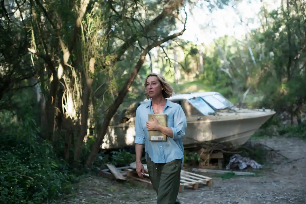 person walking in a natural setting near an abandoned boat