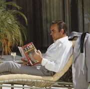 scottish actor sean connery relaxes on the set of the james bond film 'diamonds are forever', usa, may 1971 he is reading the 12th april 1971 edition of 'time' magazine, with lieutenant william calley jr on the cover photo by anwar husseingetty images