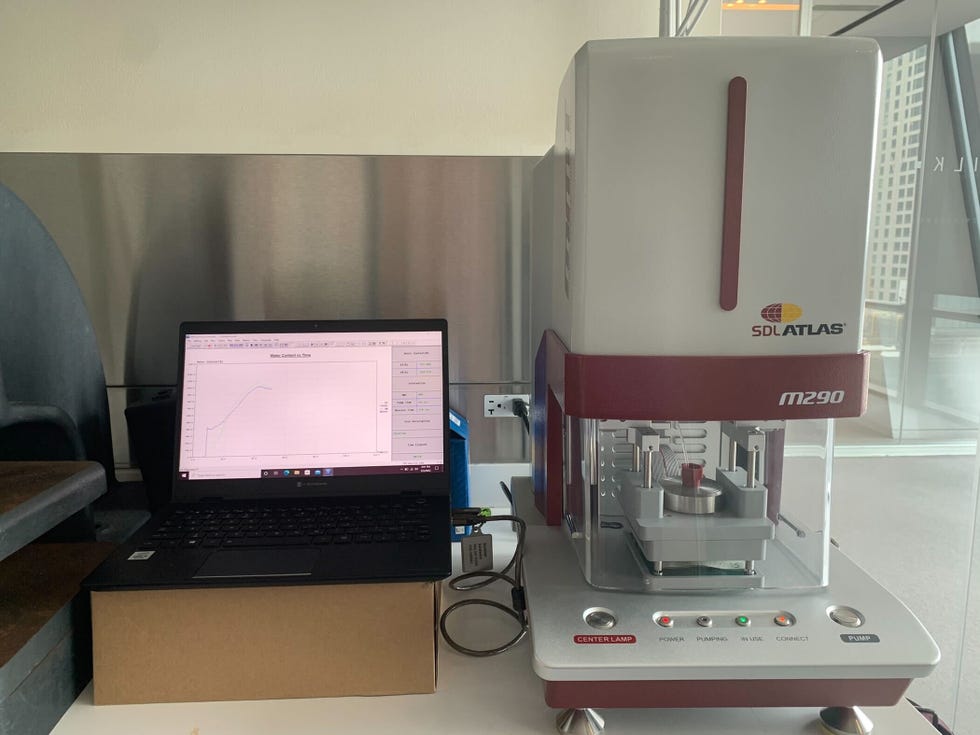 a moisture management tester is set up next to a computer to evaluate cooling sheets' ability to wick moisture