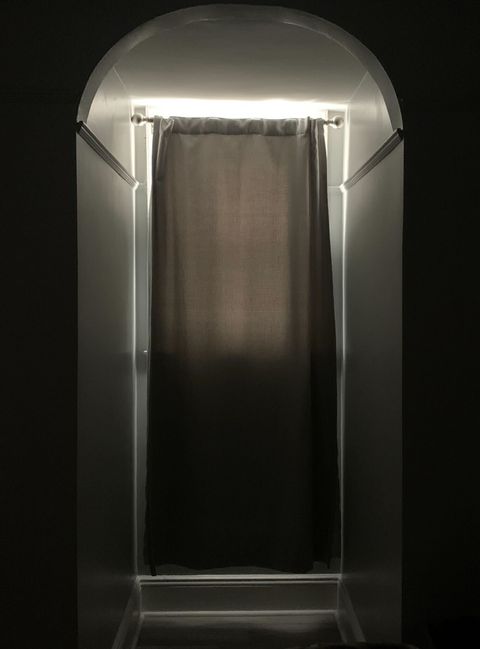 a grey blackout curtain hung in a window with light shining through