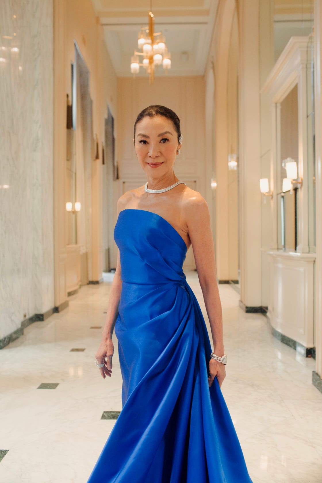 elegant figure in a blue gown in a luxurious hallway