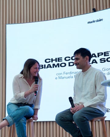 a man and a woman sitting on a bench with a microphone