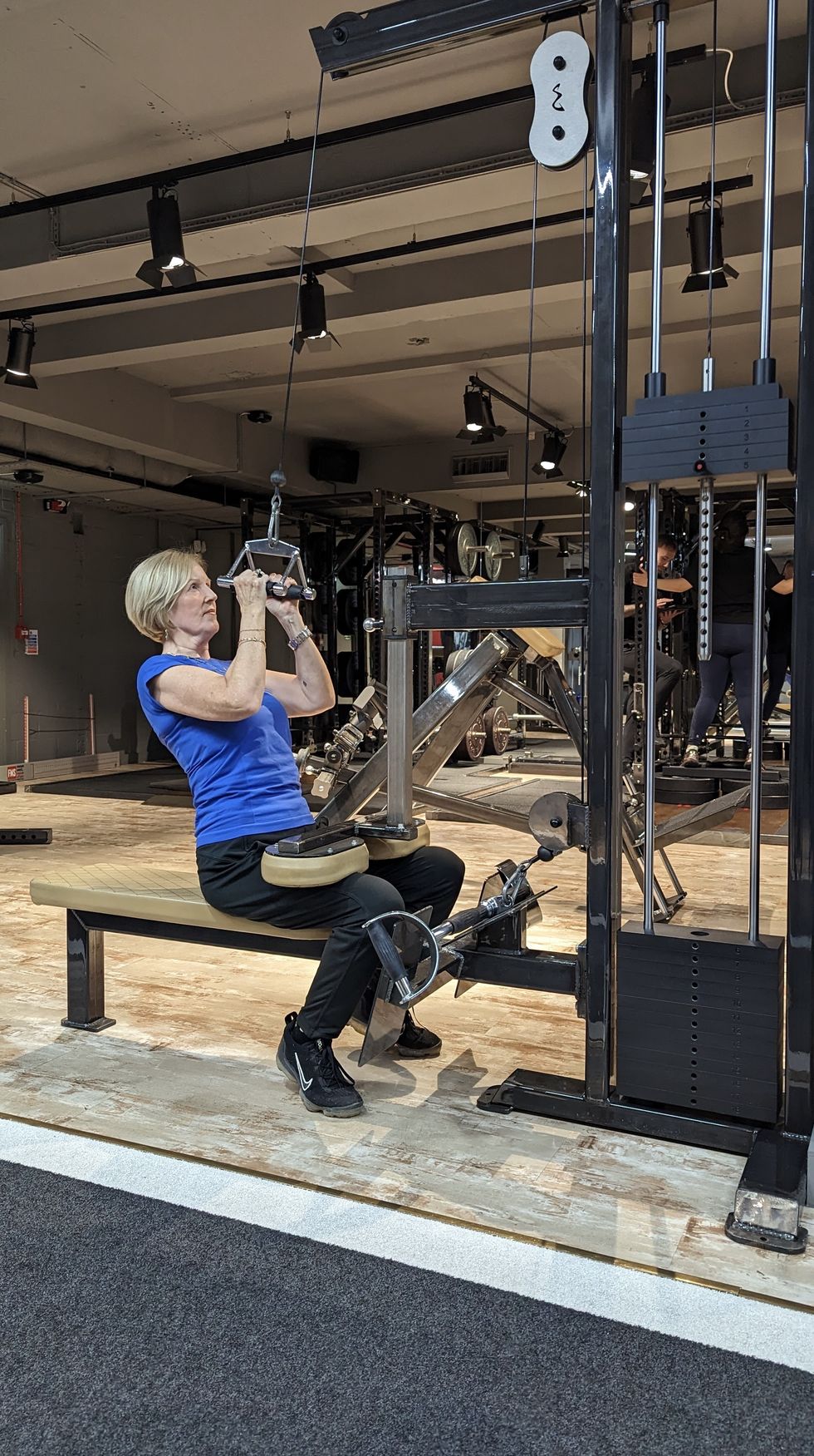 woman using weights machine at gym