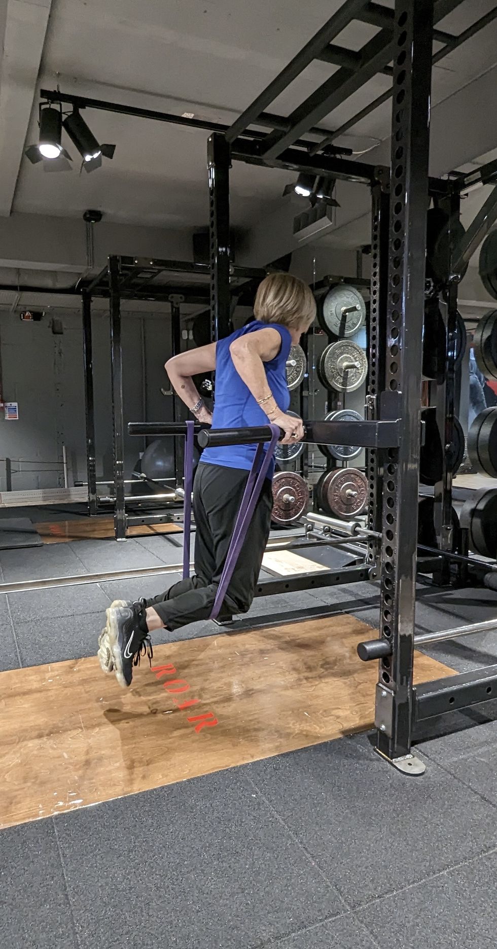 woman doing assisted tricep dips in gym