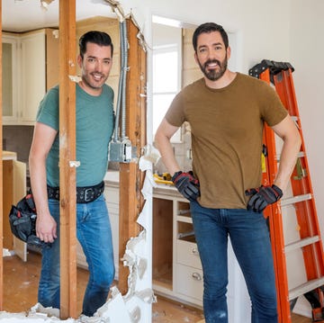 a couple of men standing in a doorway with a ladder and a door